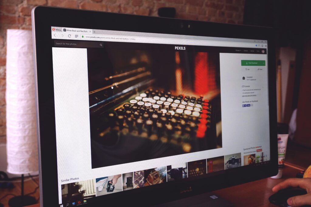 A modern desk setup with a computer monitor displaying an image of a vintage typewriter, highlighting a work environment.